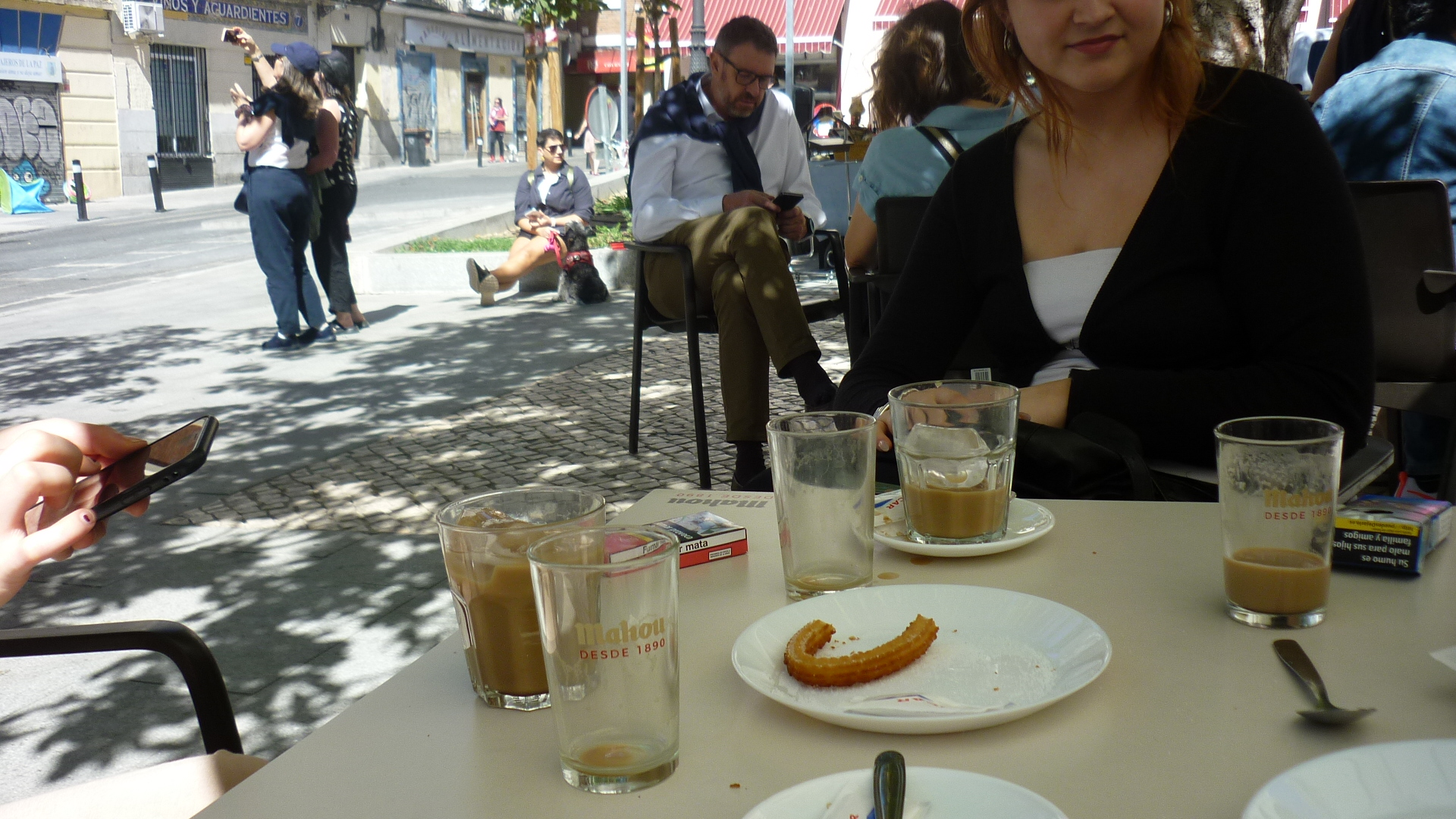 white table with cups of half drunk cofe and eaten cakes on white plates