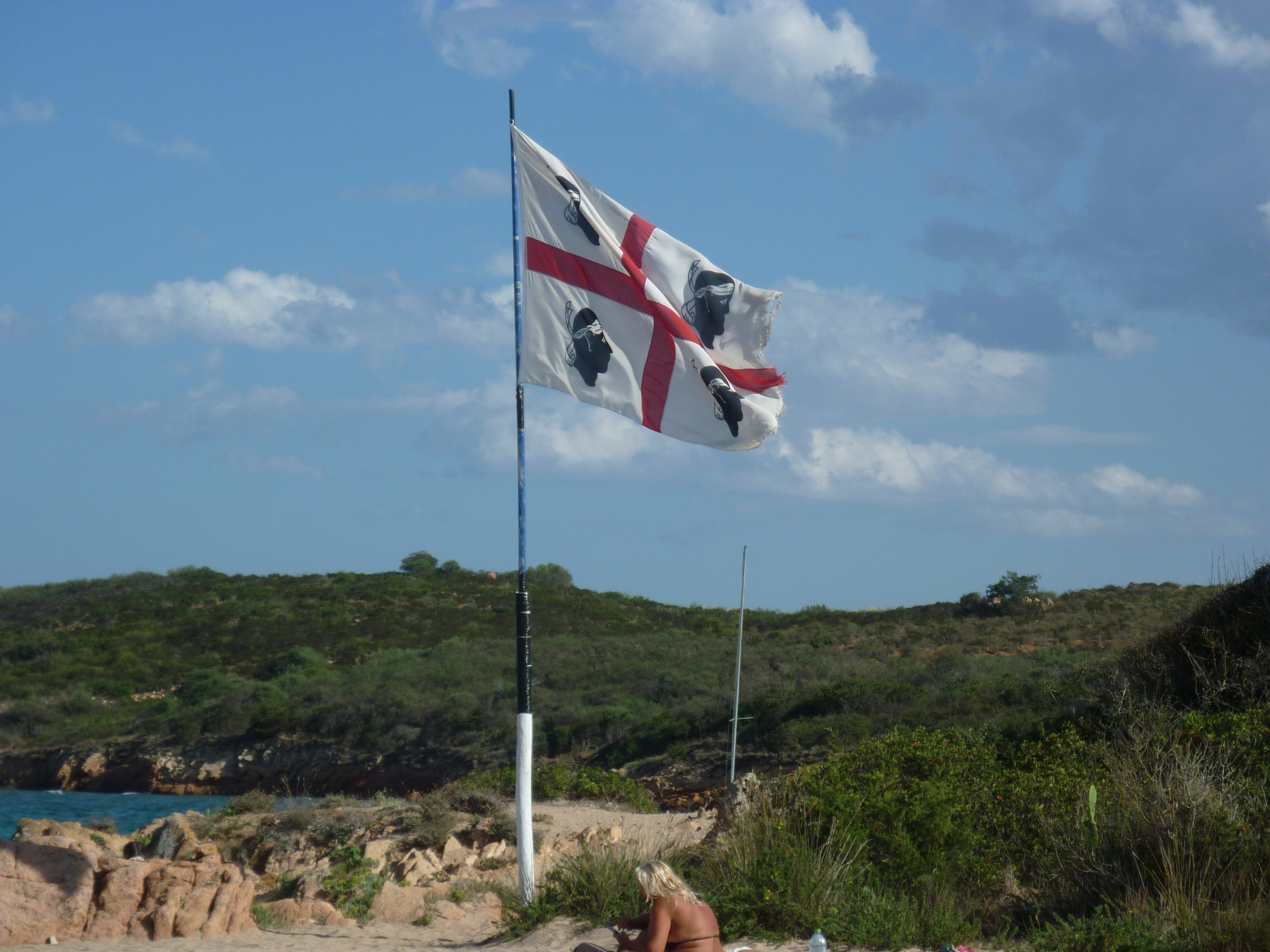 sardinian flag blowing in the wind on a beach